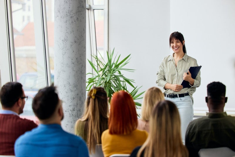 A school administrator giving a presentation to a group of coworkers