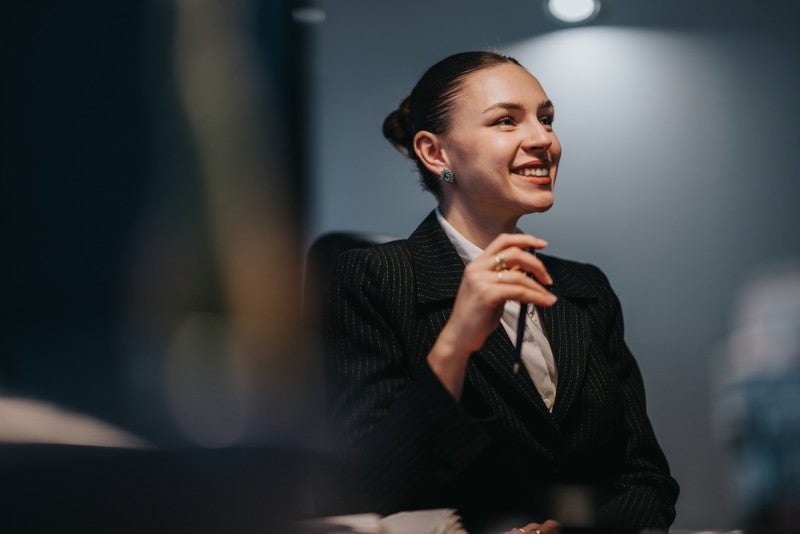 A striking portrait of a young educational leader in a suit