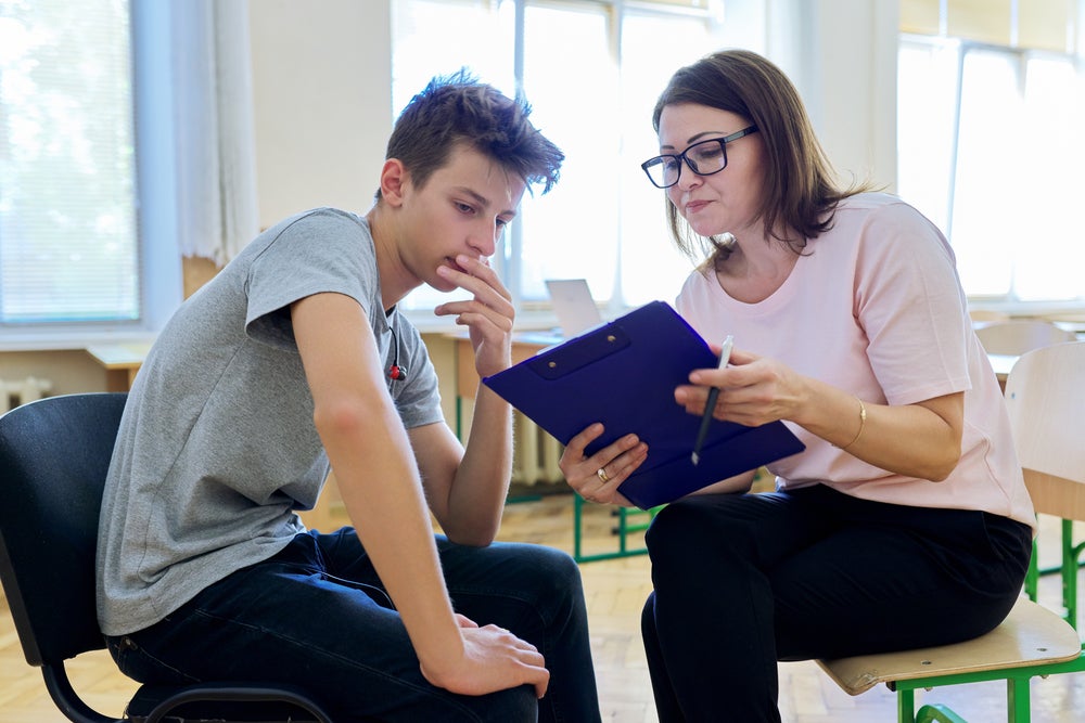 A social worker going over a care plan with their young male patient