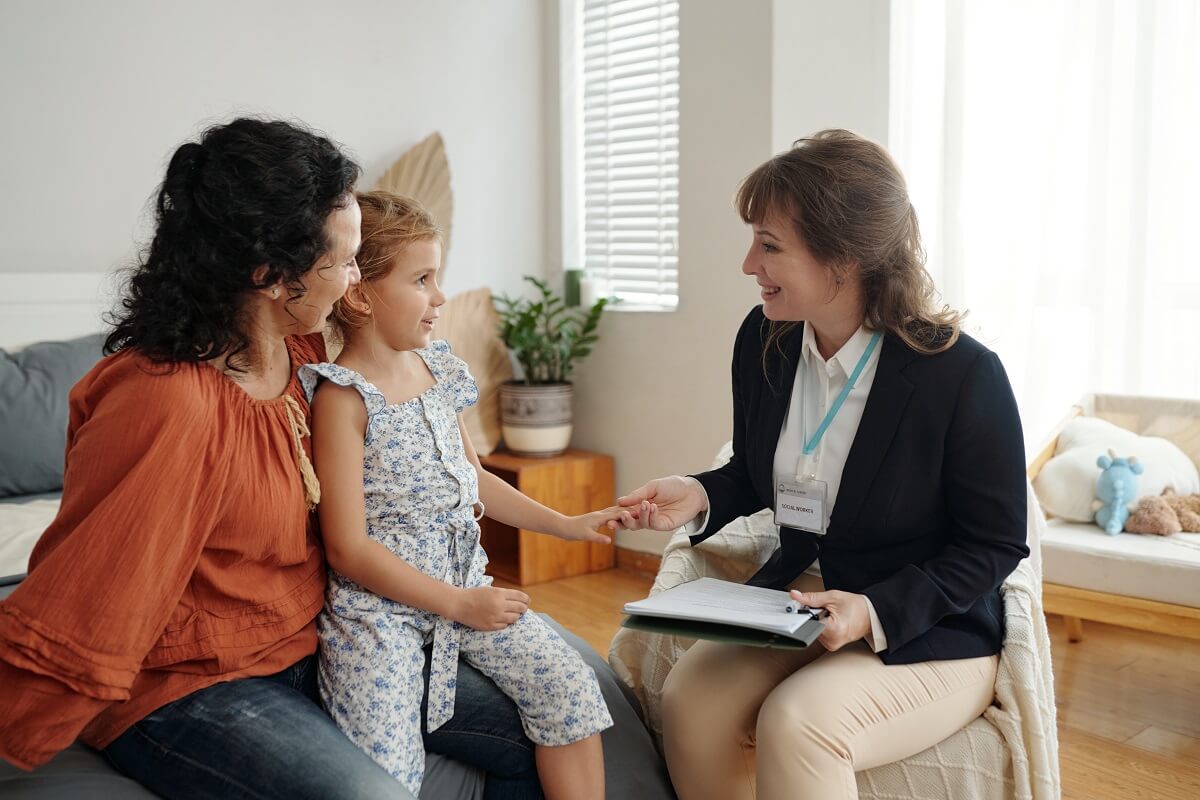 A social worker visiting a mother at home with her child