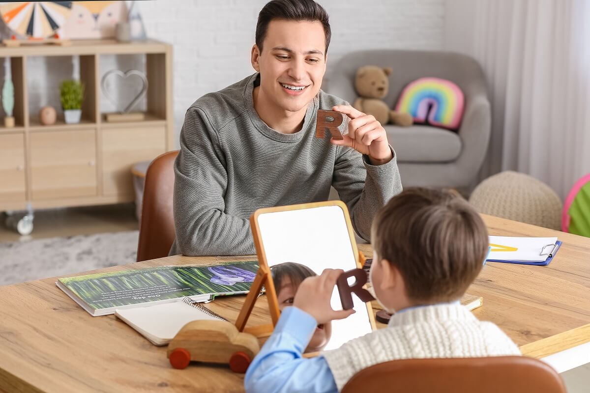 Speech Language Pathologist teaching a child to say the letter R