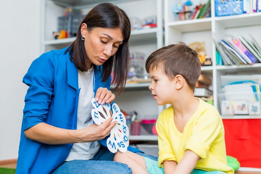 Speech-Language Pathologist helping a student learn letters