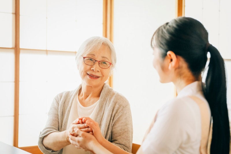 A geriatric social worker providing therapy to an older woman in a long term care facility