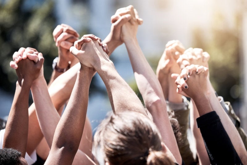 hands clasped together in a gesture of social justice