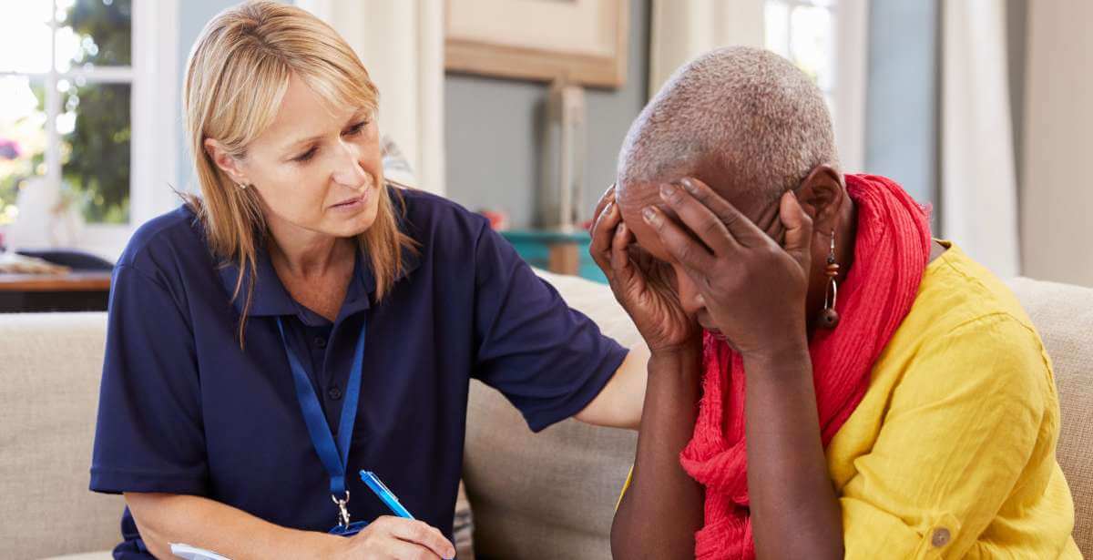 A social worker engaging in trauma-informed care with an elderly client