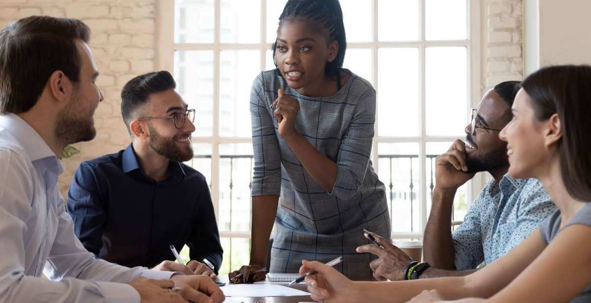 African American female executive overcoming gender barriers and leading team meeting