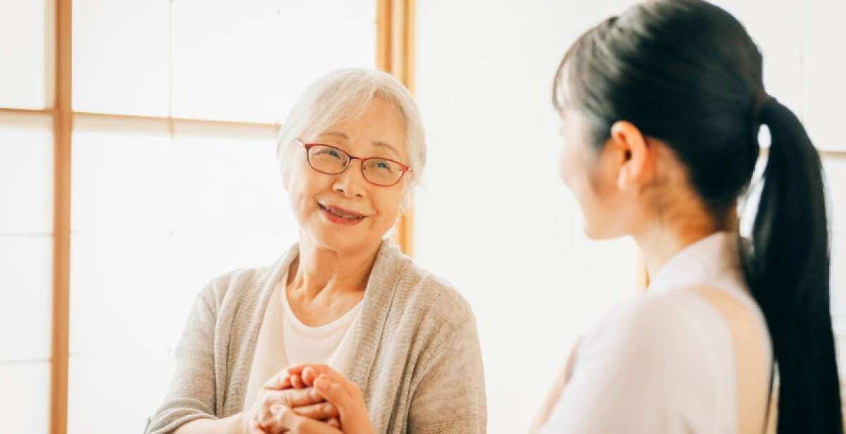 A geriatric social worker providing therapy to an older woman in a long term care facility