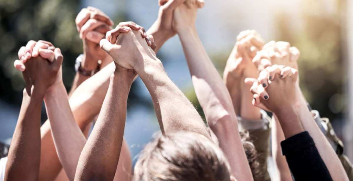 hands clasped together in a gesture of social justice