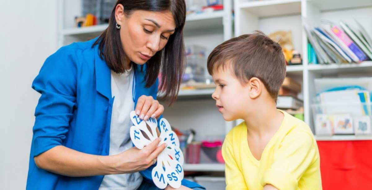 A female SLP working with a young client